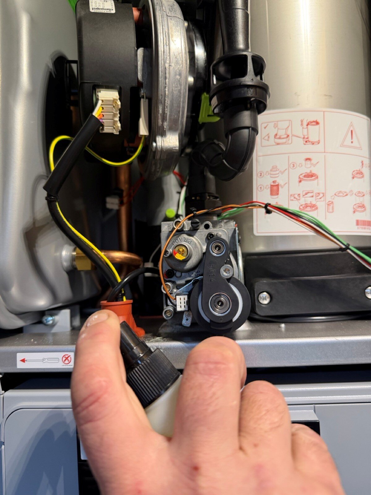 Gas engineer checking for gas leak on boiler in Epsom