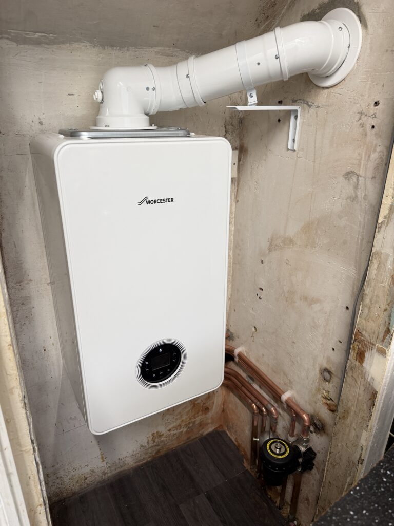 Finished Worcester boiler installation in North Cheam, showing the flue, copper pipework and system filter