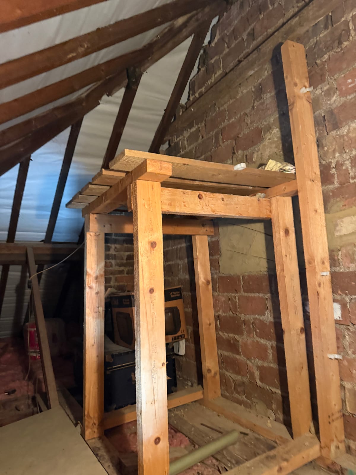 Loft space after cold-water storage tanks were removed during a combi boiler conversion in Epsom