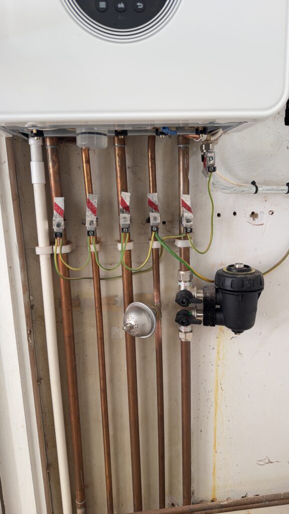 Copper pipework and system filter beneath the Worcester boiler at the Banstead installation