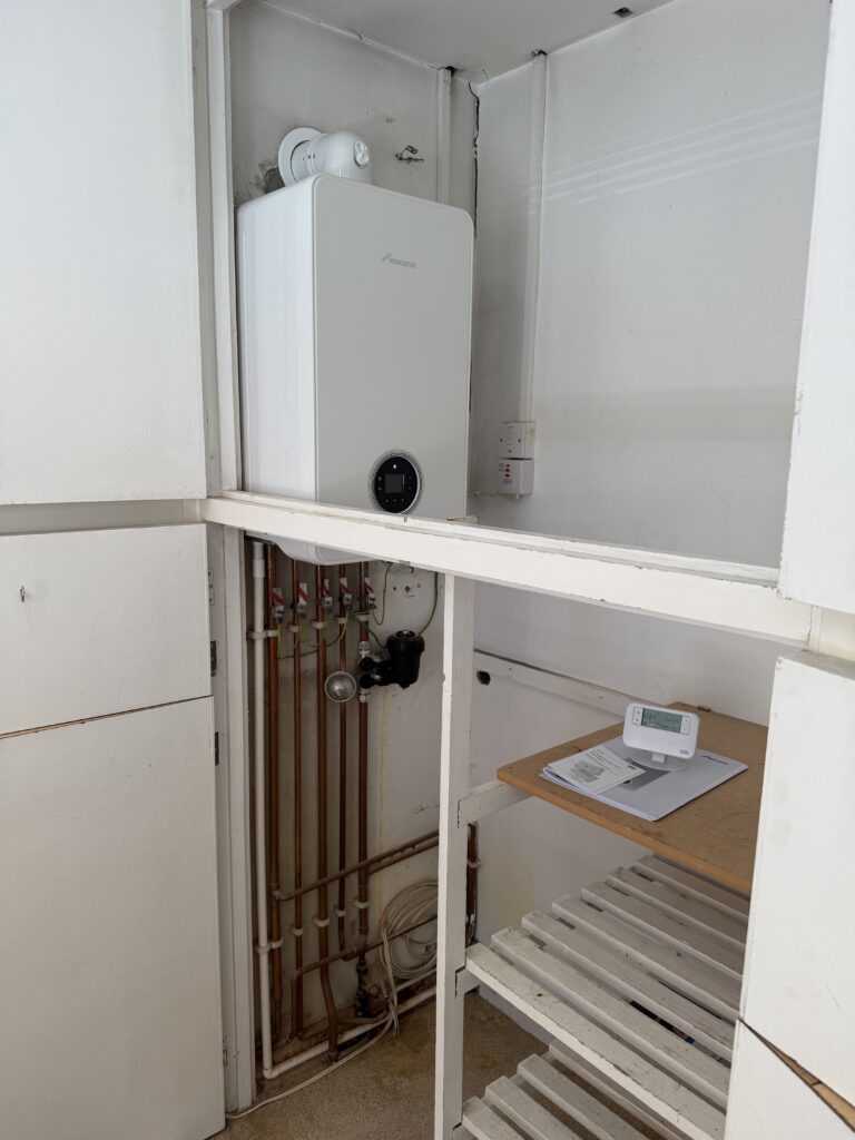 Wider view of a completed Worcester boiler installation in a Banstead airing cupboard